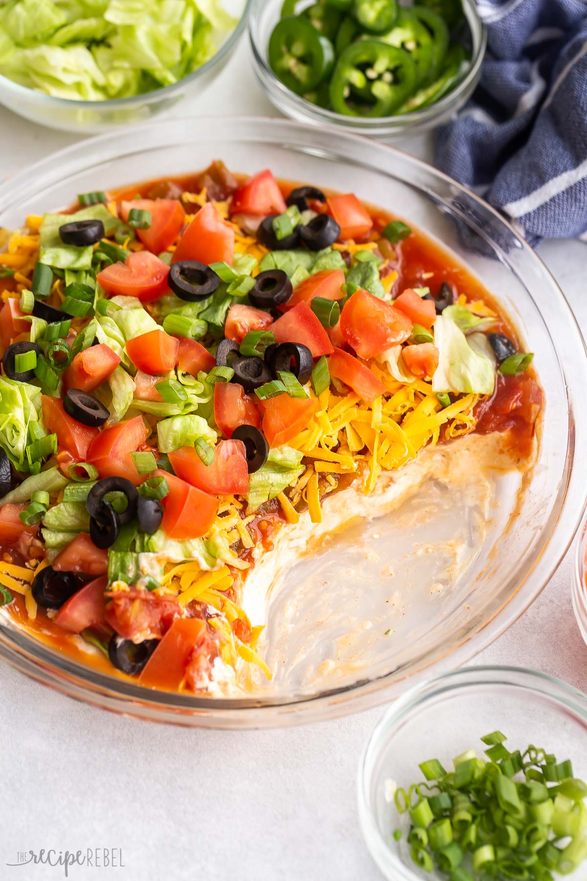 plate of taco dip with some missing to reveal layers.