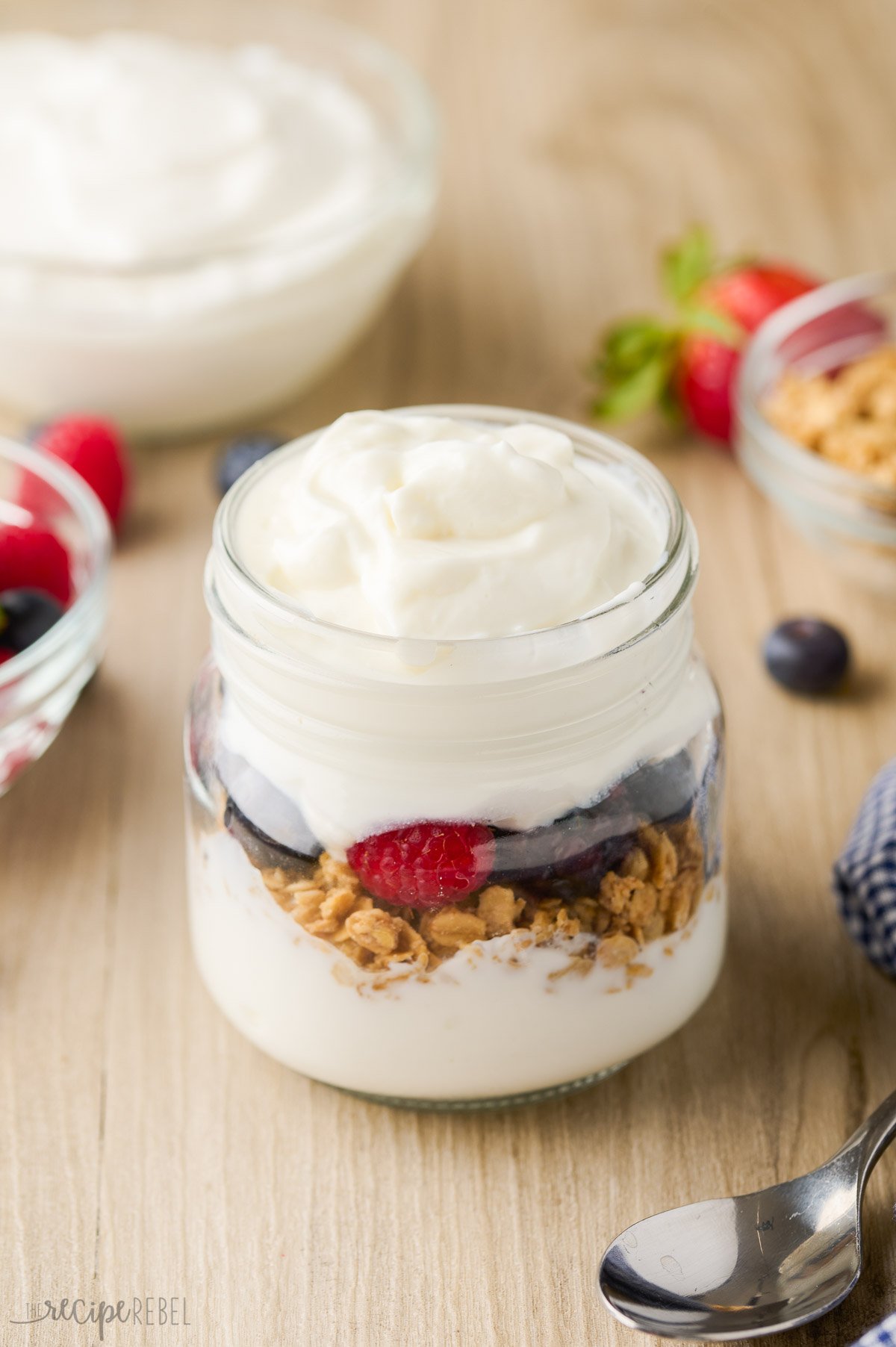 parfait ingredients layered in small glass jar ready for granola.
