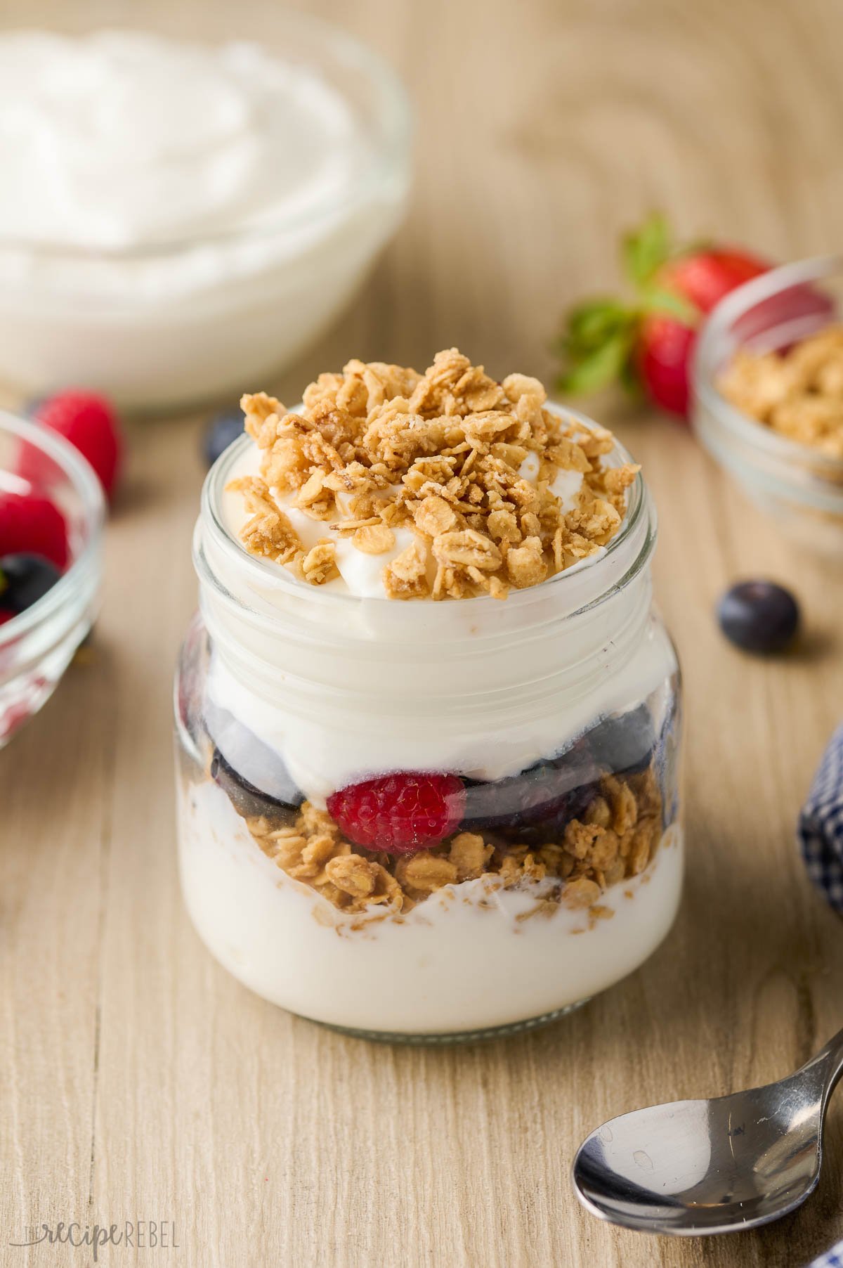 granola on top of yogurt in glass jar.