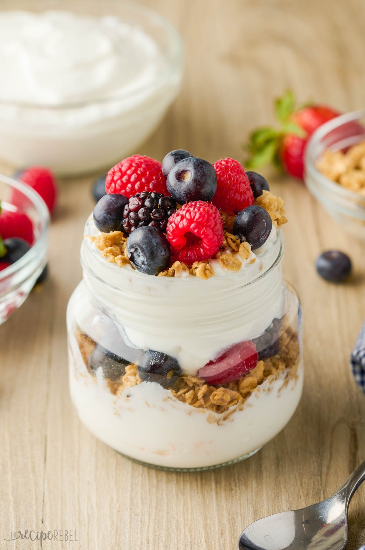 fresh raspberries blueberries and blackberries on top of yogurt parfait.