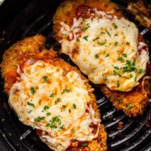 two air fryer chicken parmesan in air fryer basket.