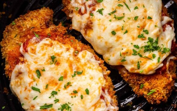 two air fryer chicken parmesan in air fryer basket.