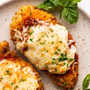 close up image of air fryer chicken parm on beige plate.