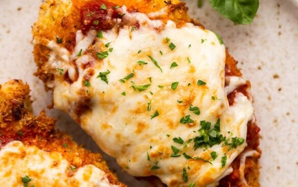 close up image of air fryer chicken parm on beige plate.