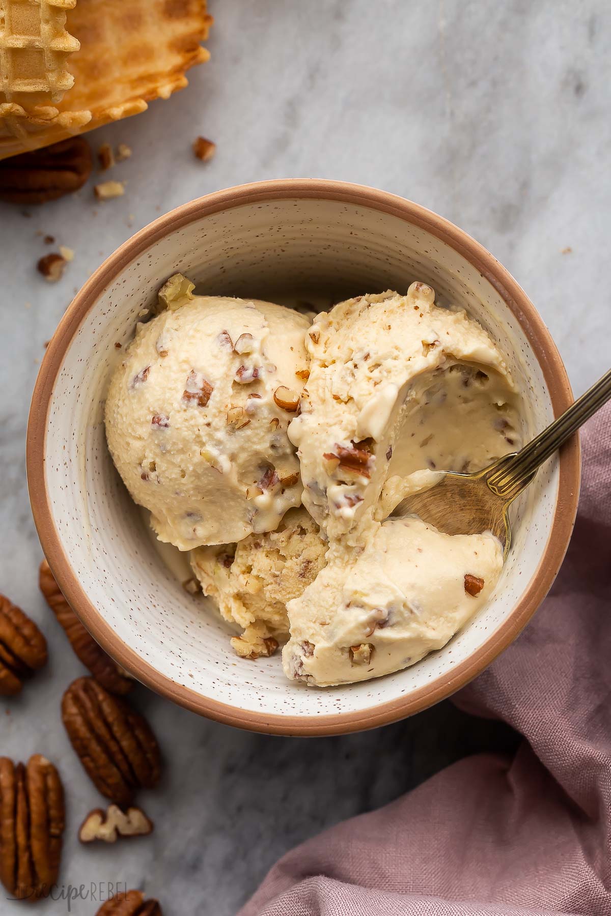 bowl of homemade butter pecan ice cream with spoon taking a scoop.