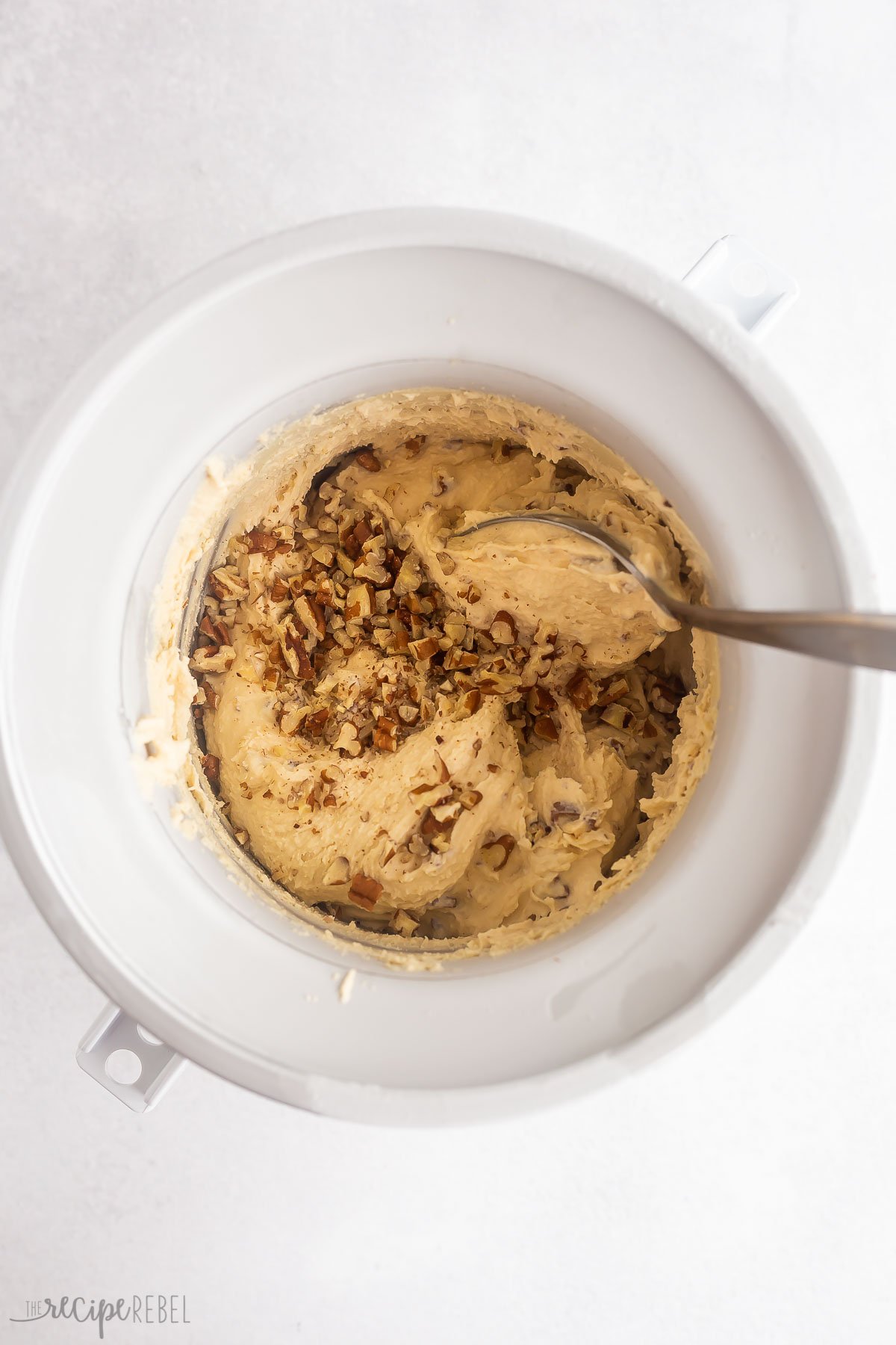 chopped pecans being added to homemade ice cream.