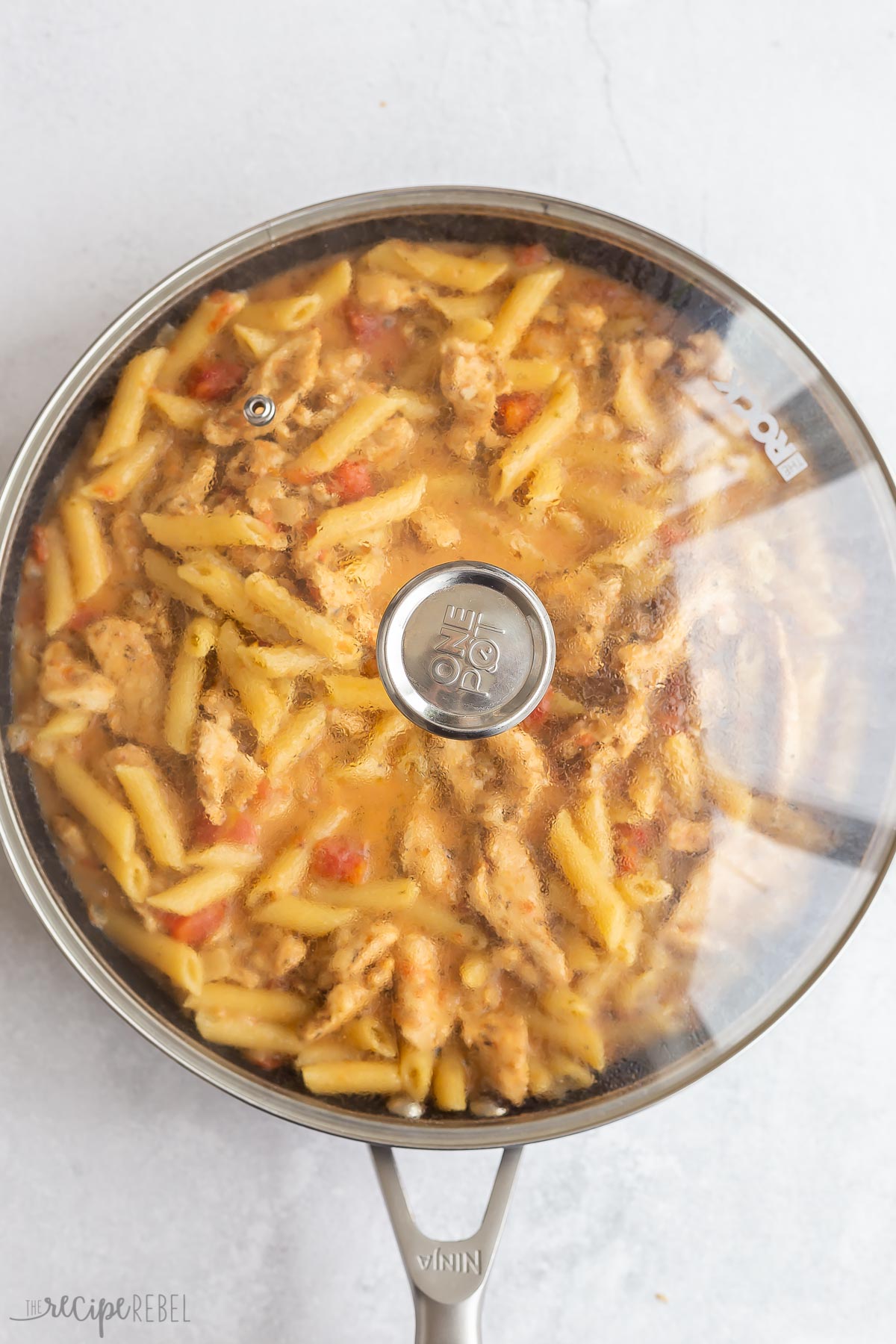 pasta covered and cooking in skillet.