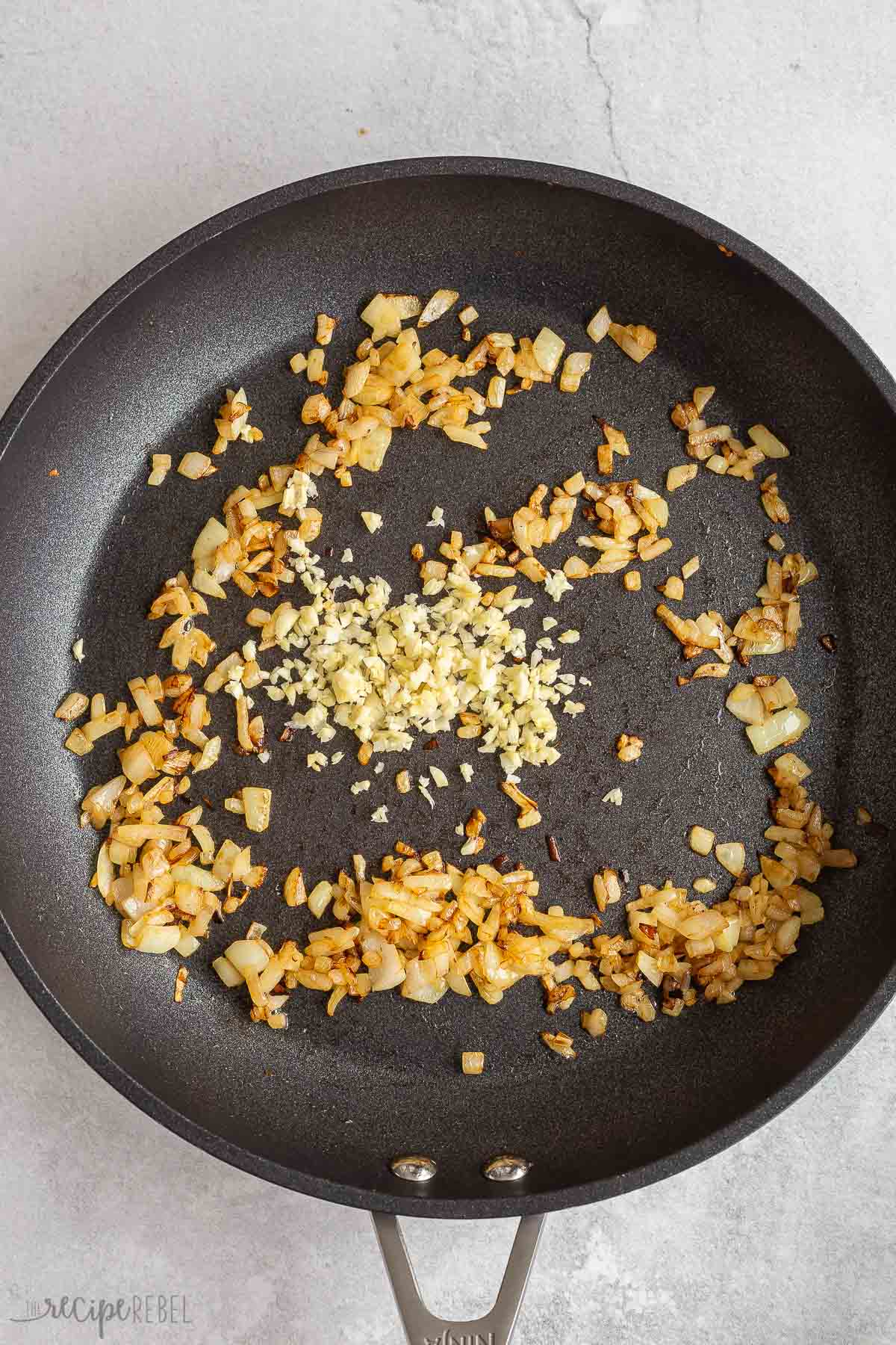 onion and spices cooking in black skillet.