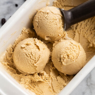 three scoops of coffee ice cream in white glass loaf pan.