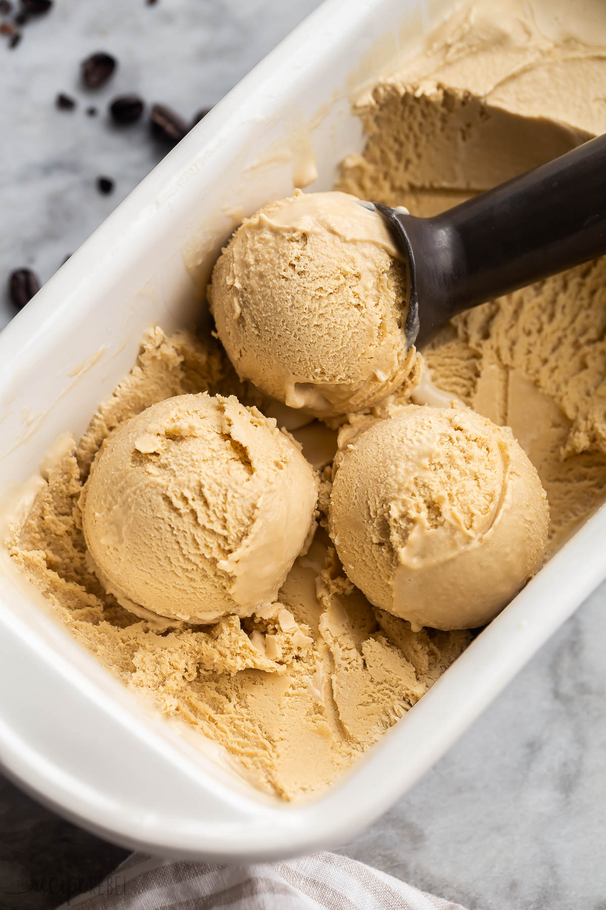 three scoops of coffee ice cream in white glass loaf pan.