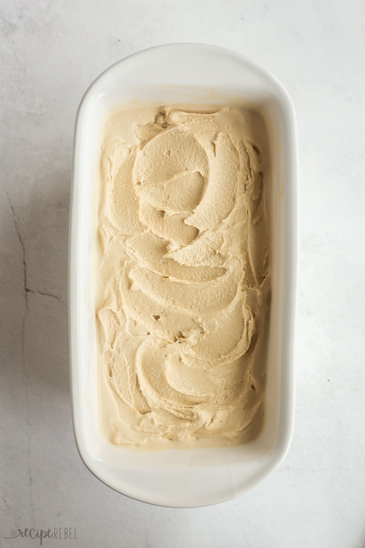 coffee ice cream base spread into white glass loaf pan.