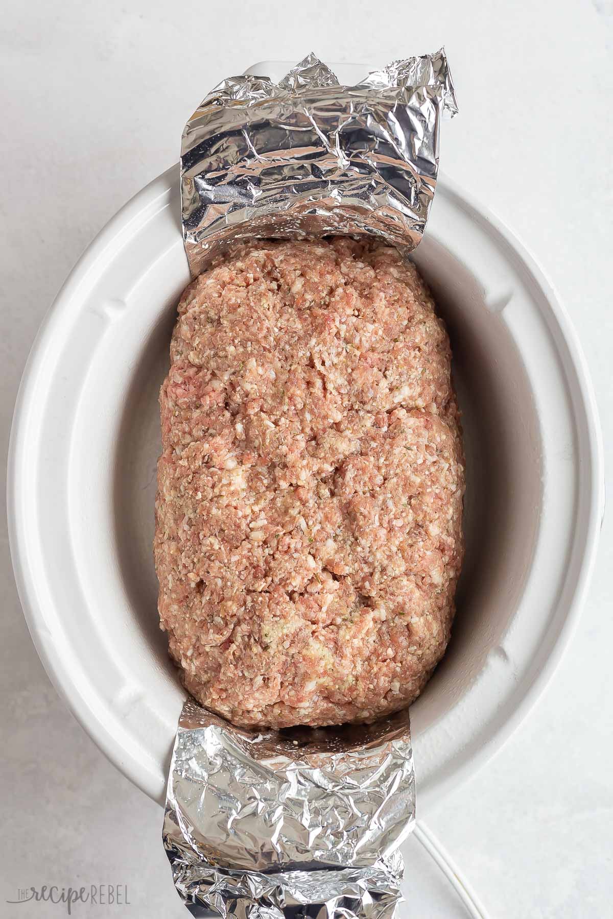 uncooked meatloaf formed in crockpot.