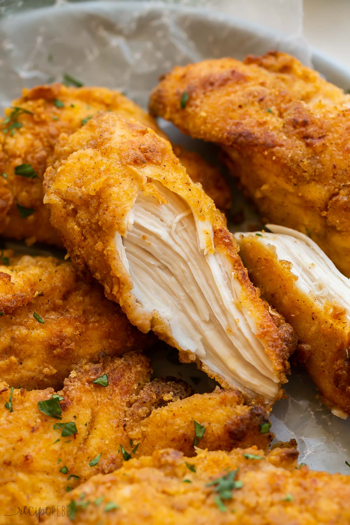 close up image of baked fried chicken split in half.