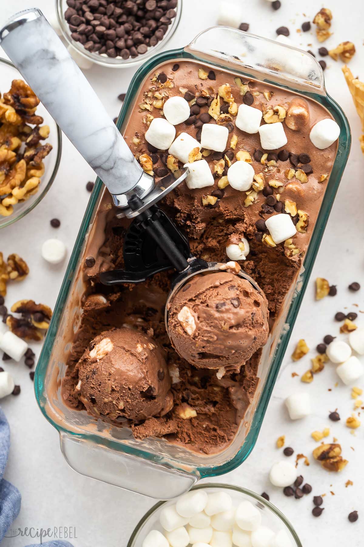 glass loaf pan with rocky road ice cream and two scoops of ice cream.
