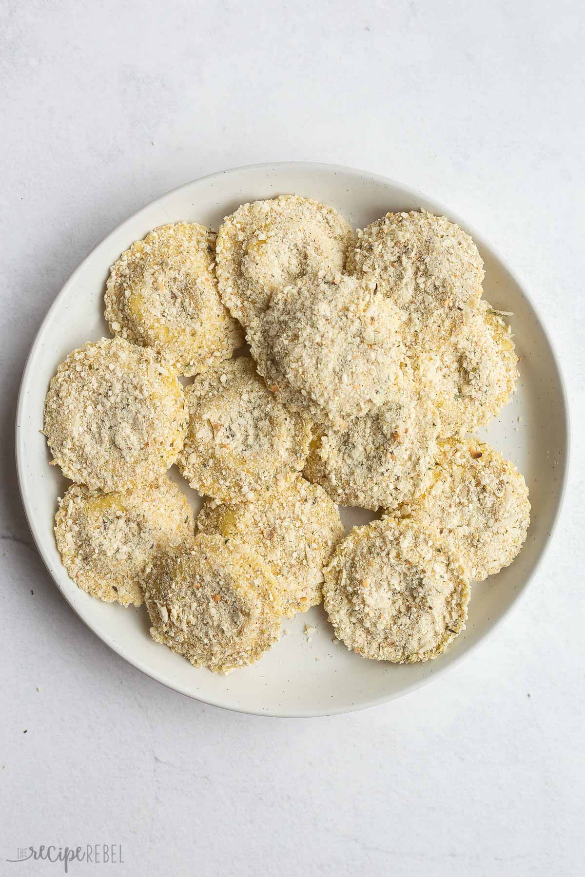 bread crumb coated ravioli on a white plate.