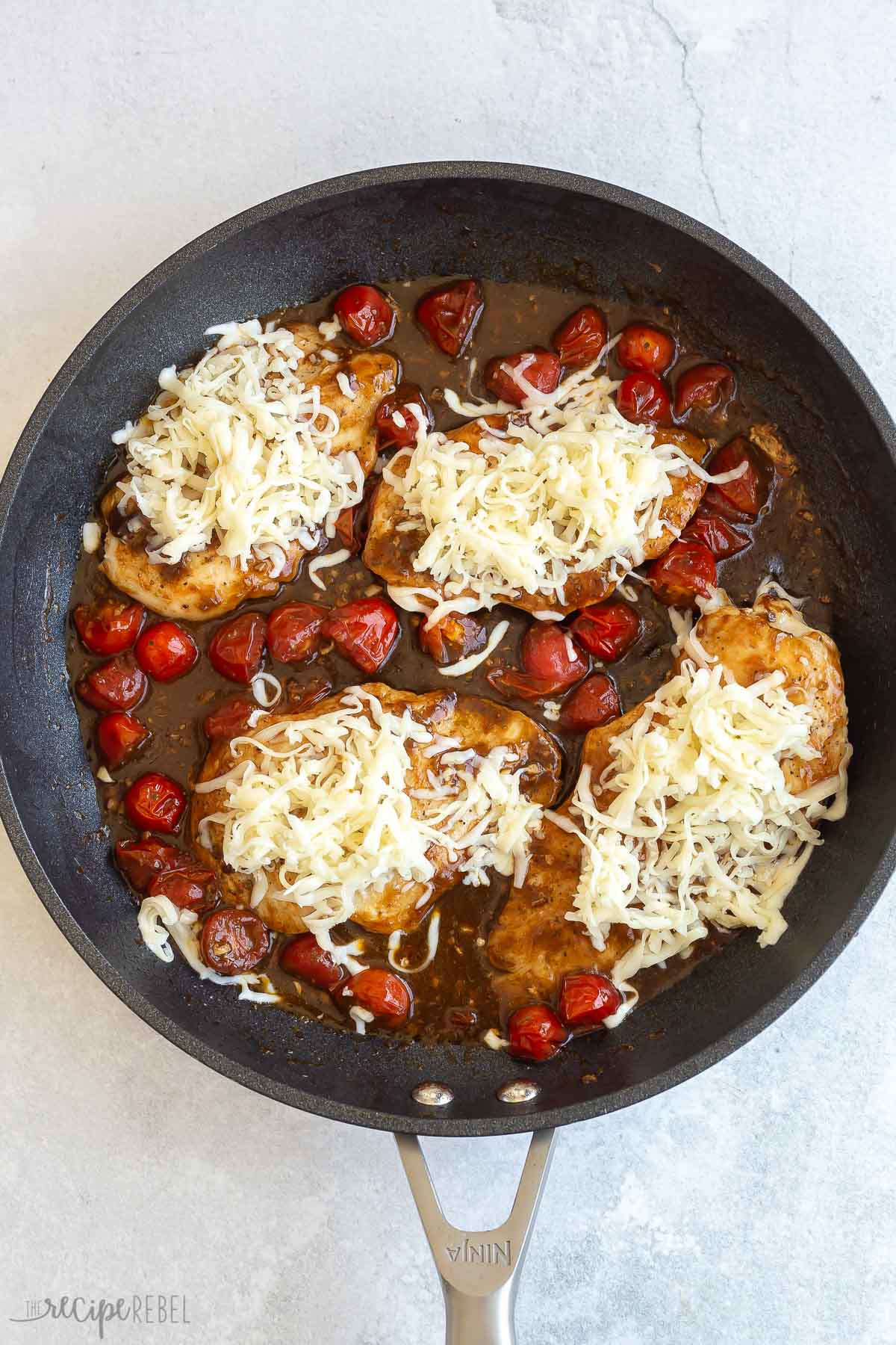 shredded mozzarella cheese on top of caprese chicken breasts.