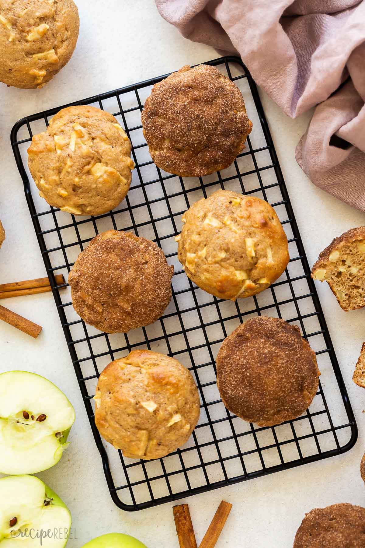 apple cinnamon muffins on cooling rack, some with cinnamon sugar.