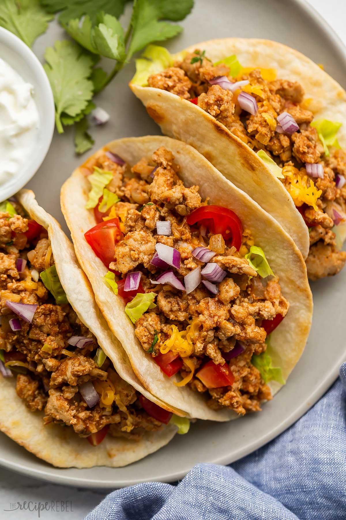 close up image of ground turkey tacos with tomatoes and red onion.