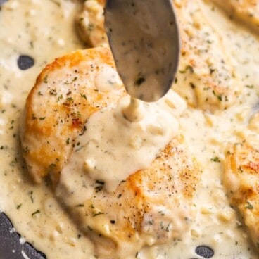 close up image of spoon drizzling sauce on chicken.