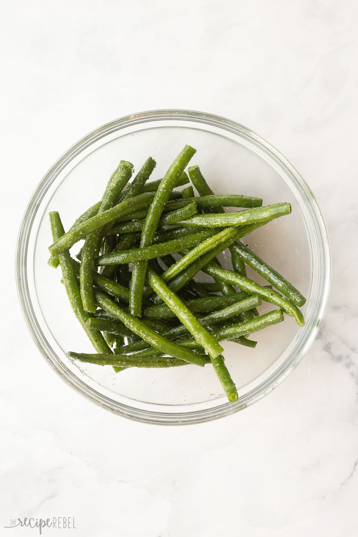 fresh green beans in bowl with seasonings.