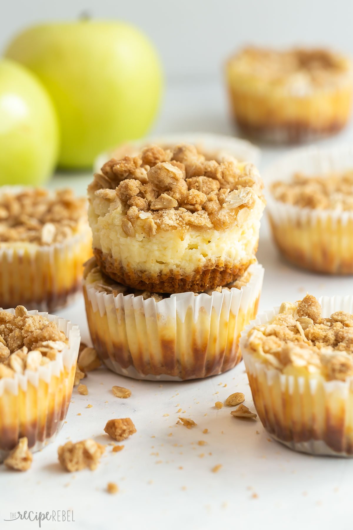 one cheesecake unwrapped sitting on top of another apple cheesecake in a muffin wrapper.