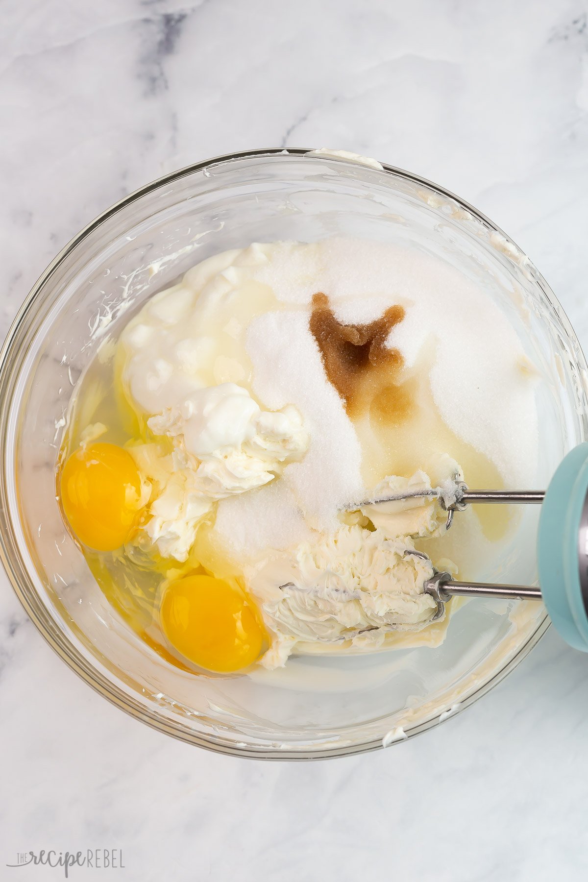 wet ingredients for cheesecake filling in glass bowl.