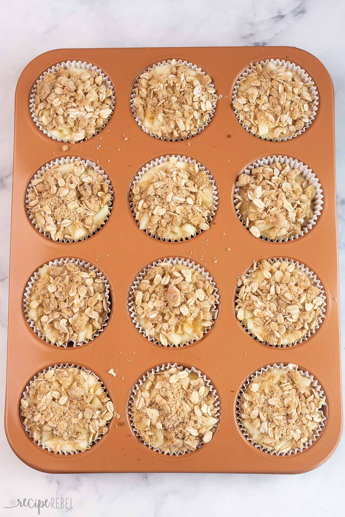 mini cheesecakes topped with streusel in muffin pan.