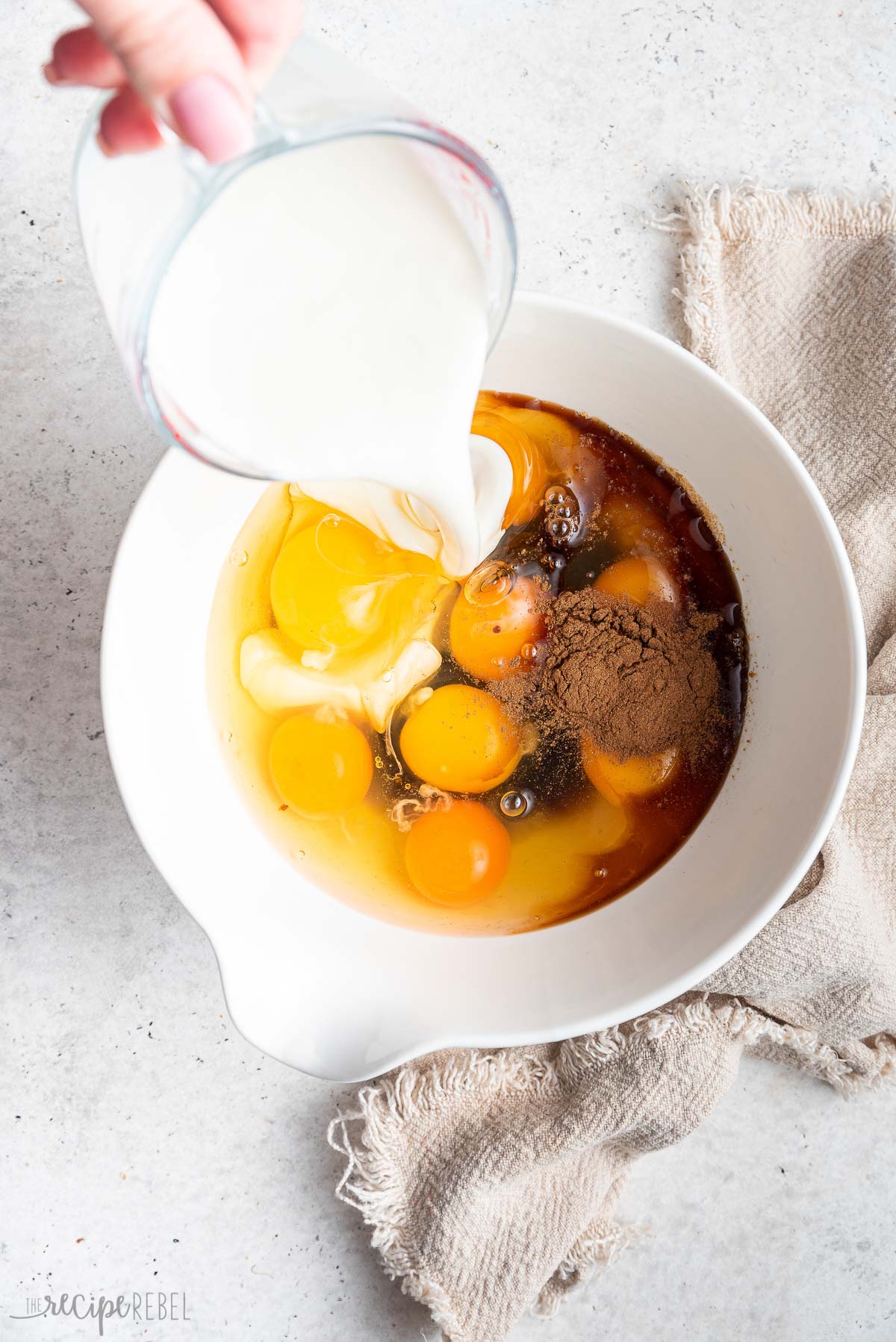 french toast batter ingredients added to white bowl.