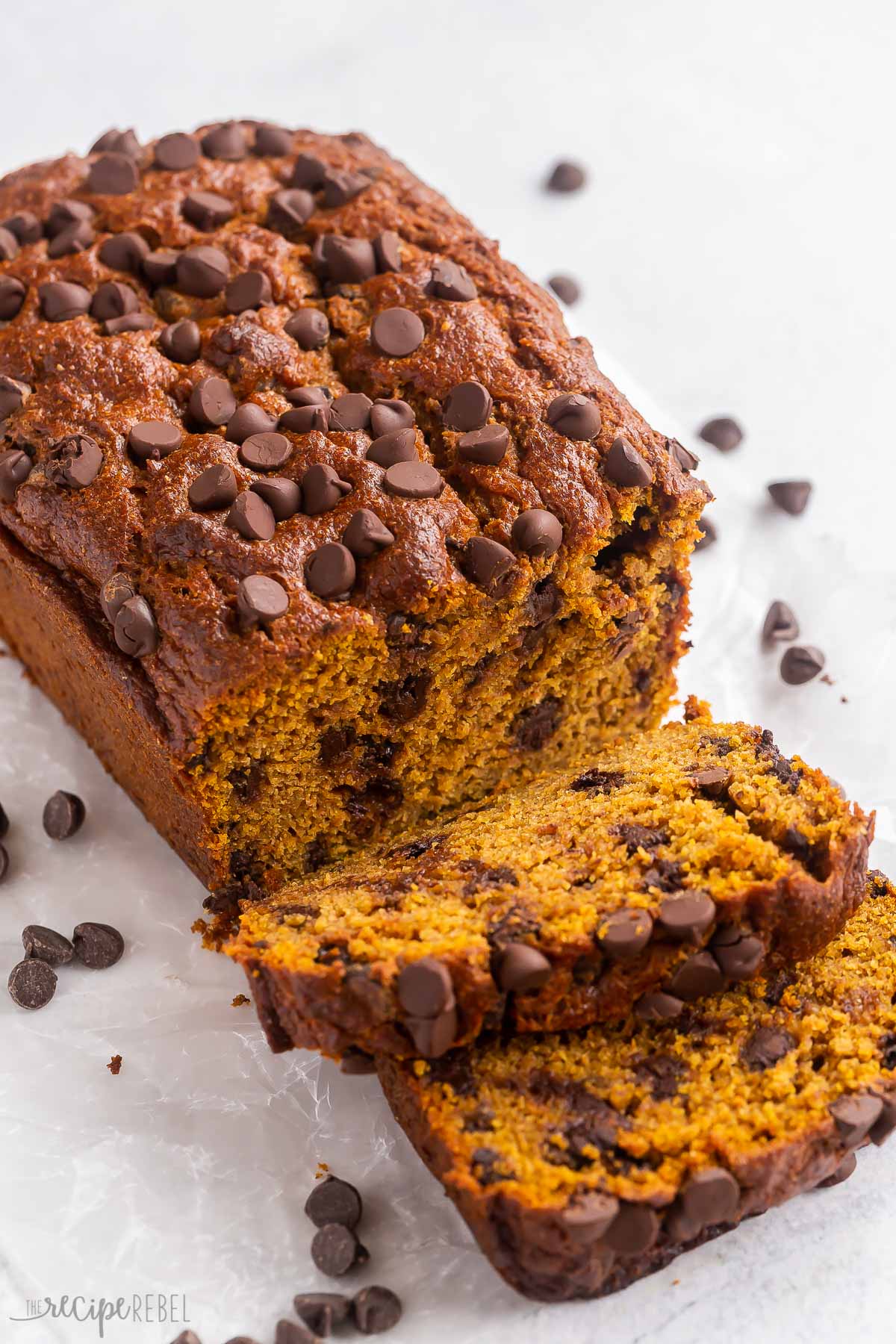 close up image of pumpkin chocolate chip bread with two slices cut.