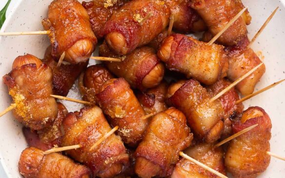 overhead image of bacon wrapped smokies in white bowl with toothpicks in.