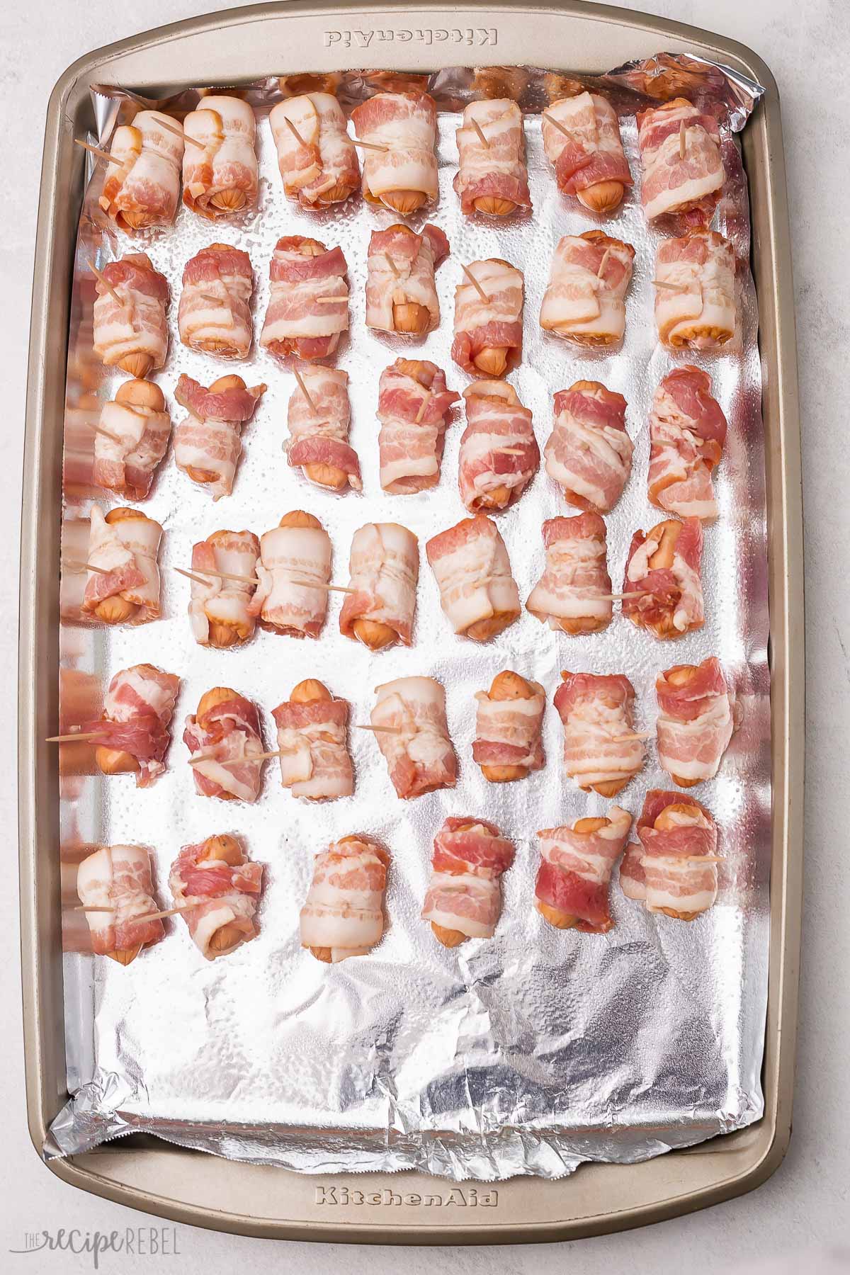 bacon wrapped smokies on a foil lined baking sheet.