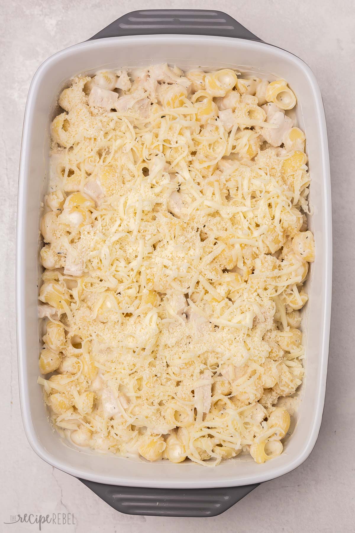 alfredo sauce cooked pasta chicken and cheese in baking dish.