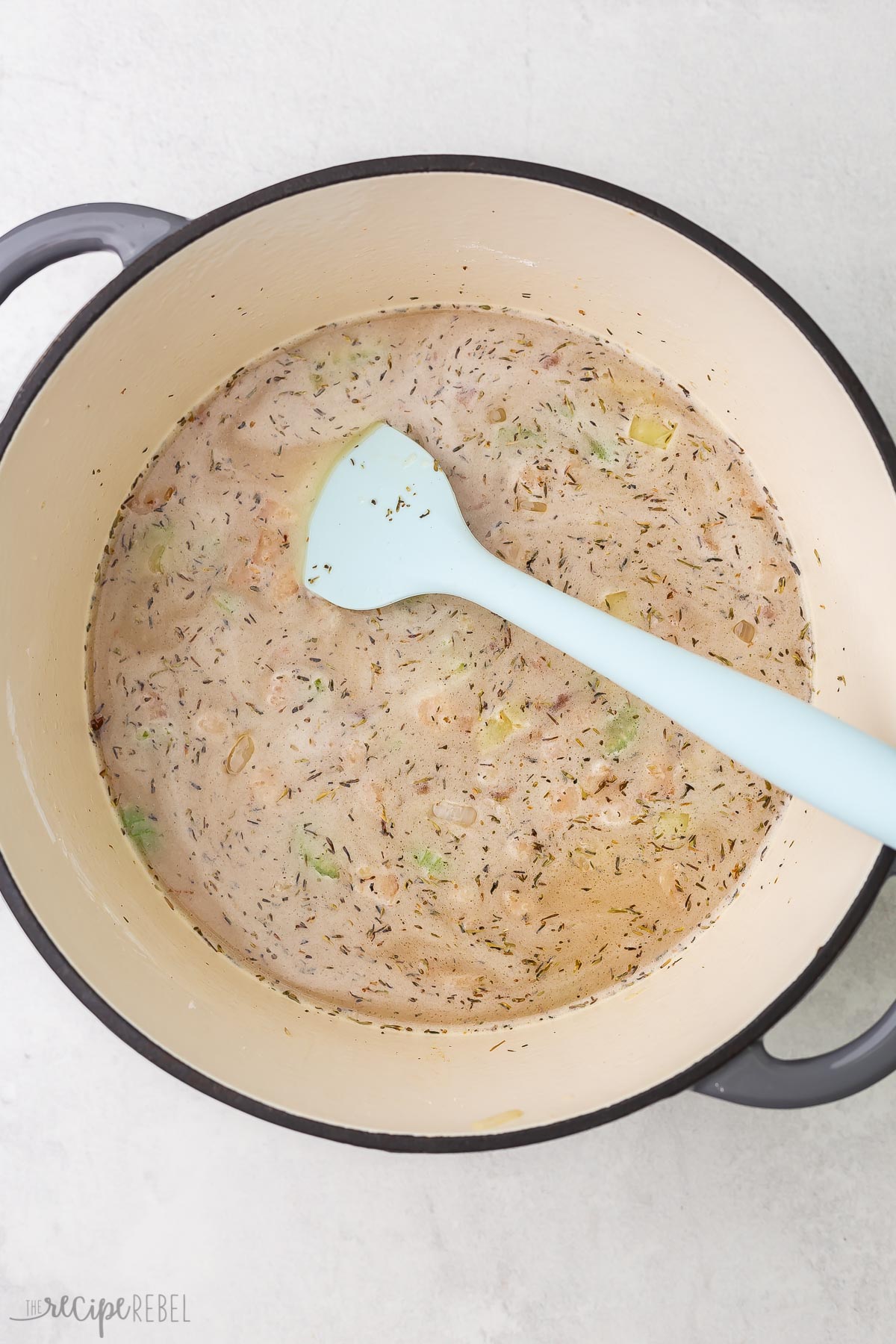 broth added to vegetables and bacon in soup pot.