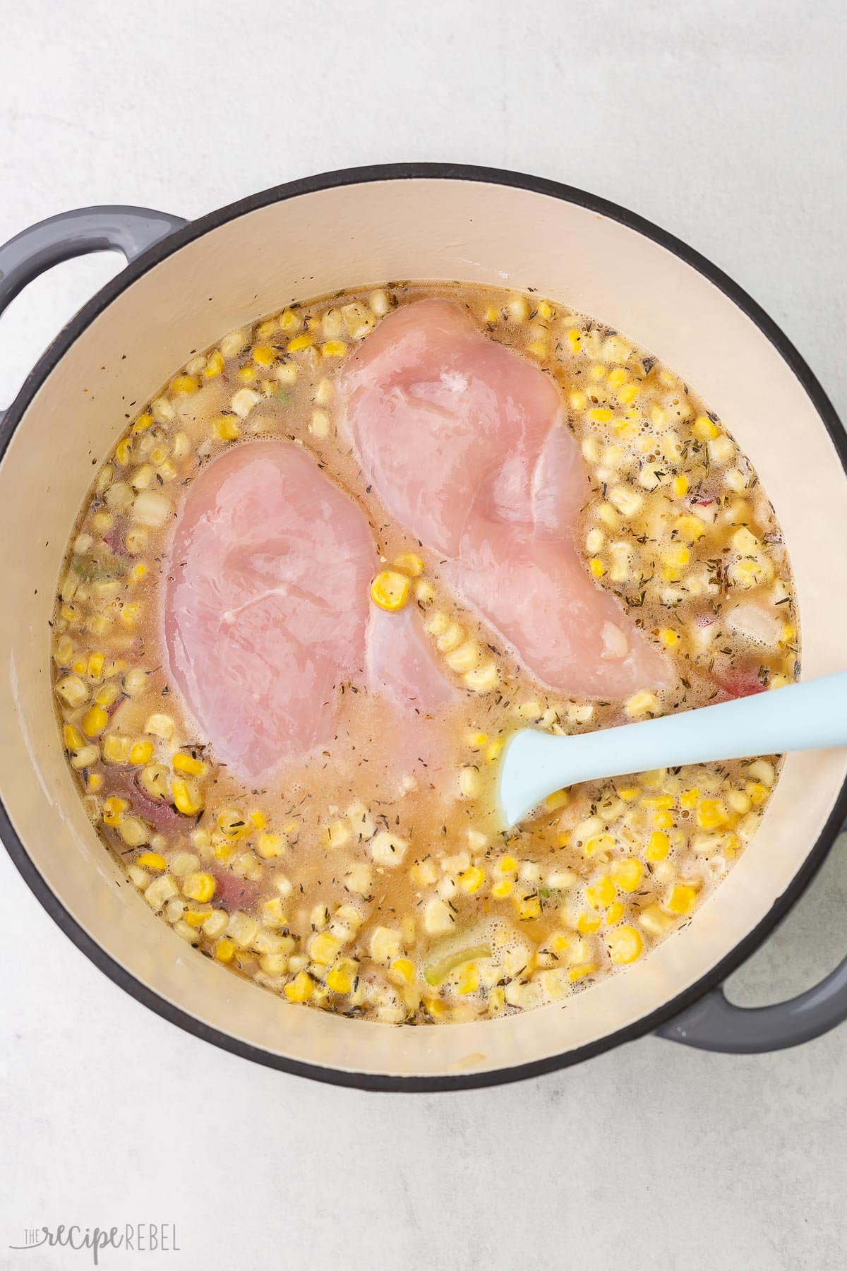 corn potatoes and raw chicken added to soup to simmer.