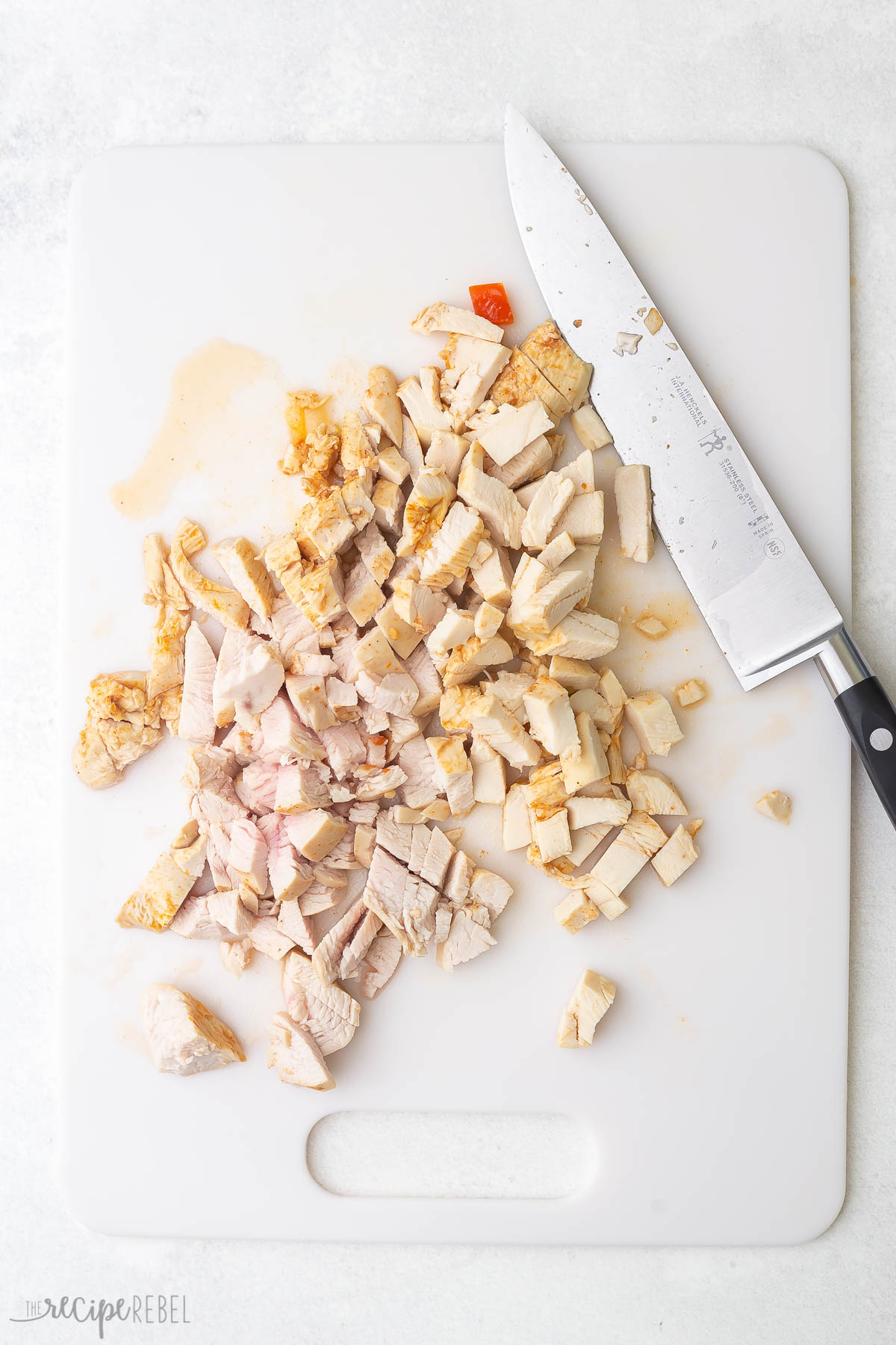 chicken cooked and chopped on cutting board.