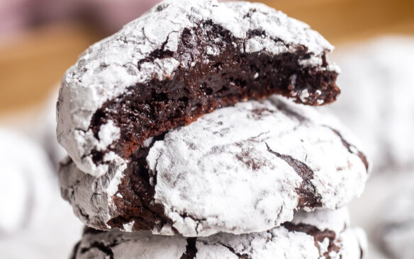 square image of chocolate crinkle cookies stacked.