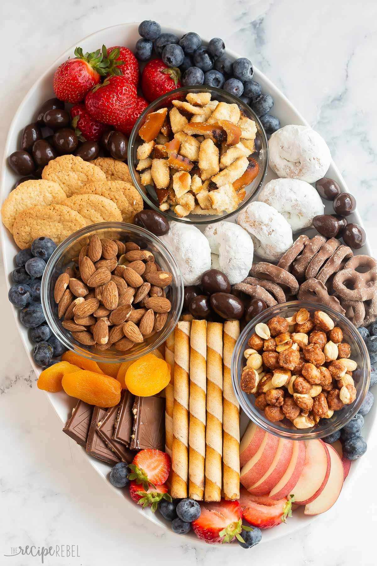 overhead image of dessert charcuterie board with cookies chocolates nuts and fruit.