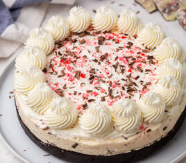 no bake peppermint bark cheesecake on a white plate.
