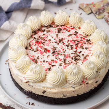 no bake peppermint bark cheesecake on a white plate.