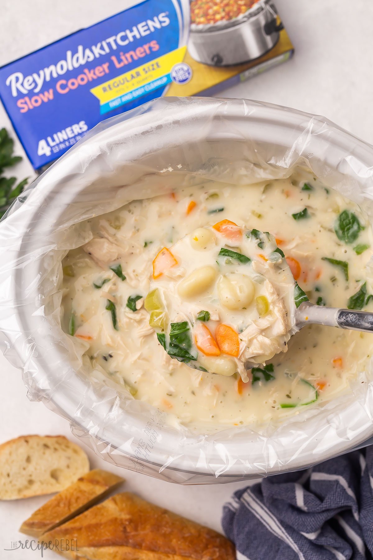 crockpot of chicken gnocchi soup in crockpot with slow cooker liner.