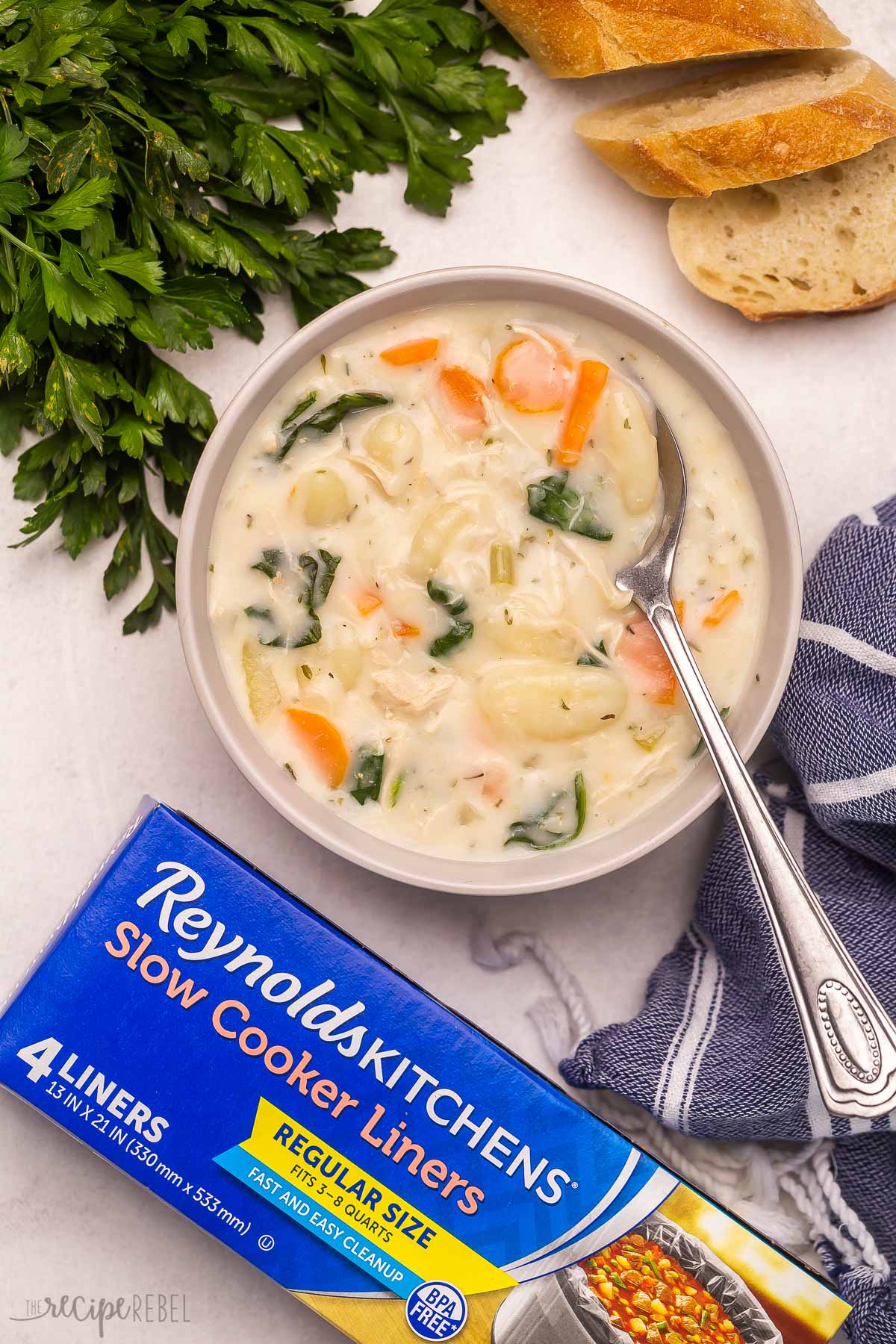 bowl of chicken gnocchi soup with box of Reynolds slow cooker liners on the side.