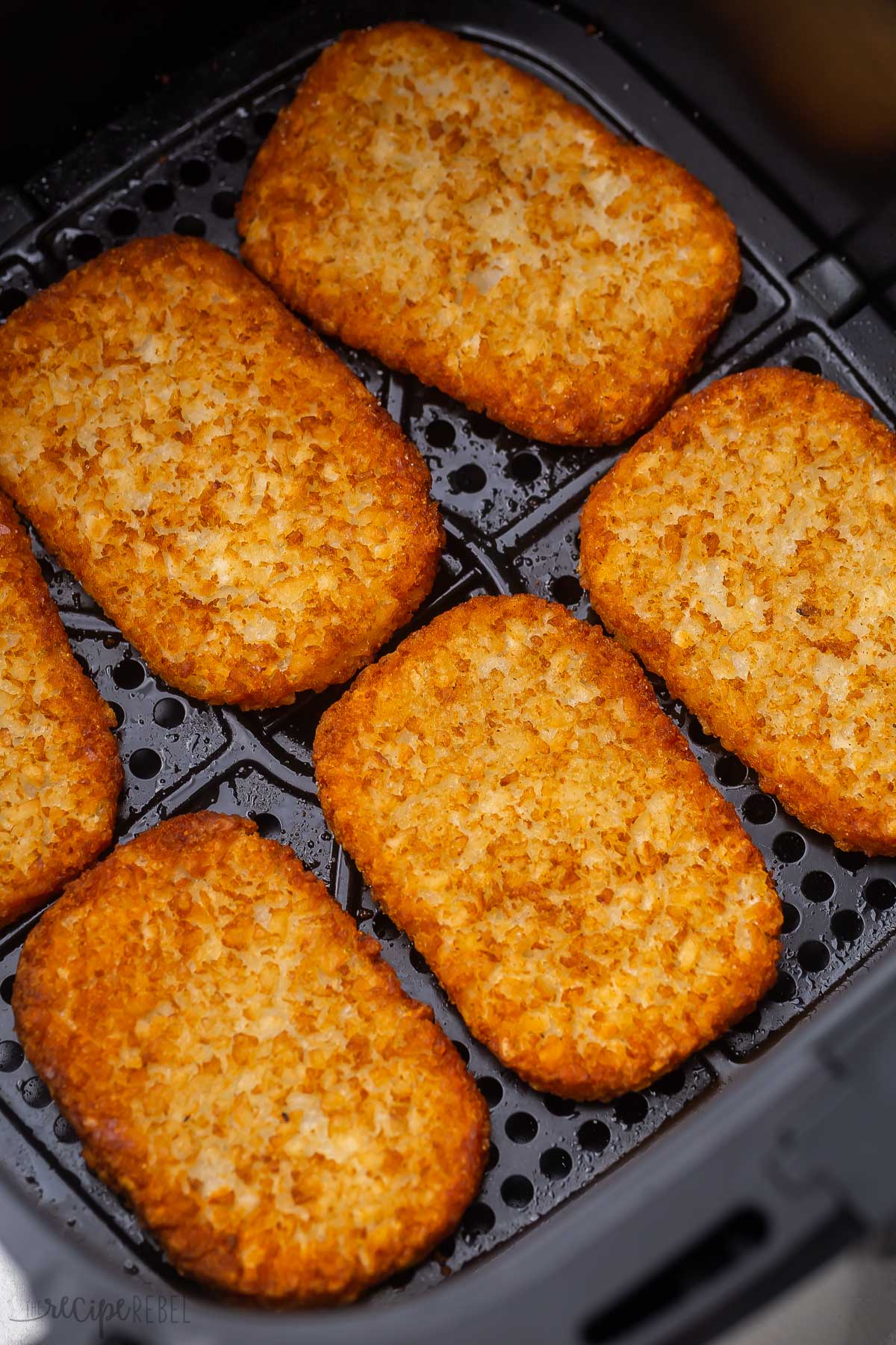 close up shot of fried hash browns in air fryer basket.