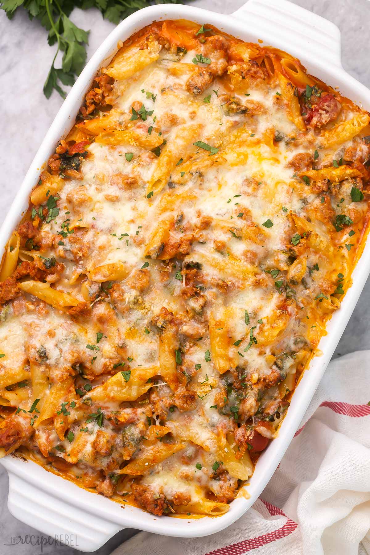 white pan of baked mostaccioli pasta on grey surface.