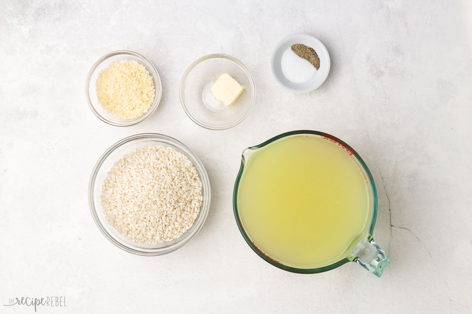 Top view of baked risotto ingredients on a grey surface.