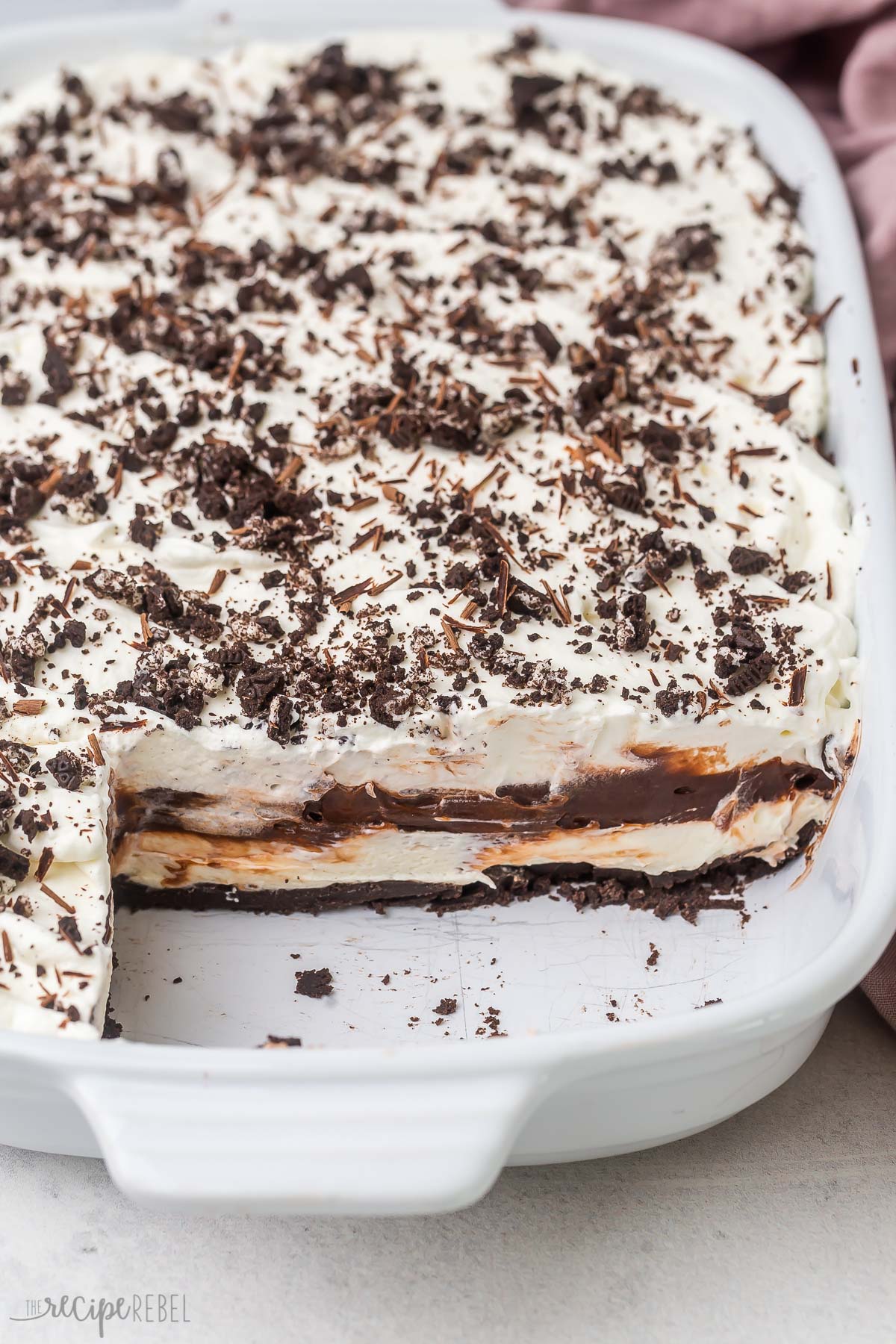 a white pan of chocolate lasagna with two pieces missing.