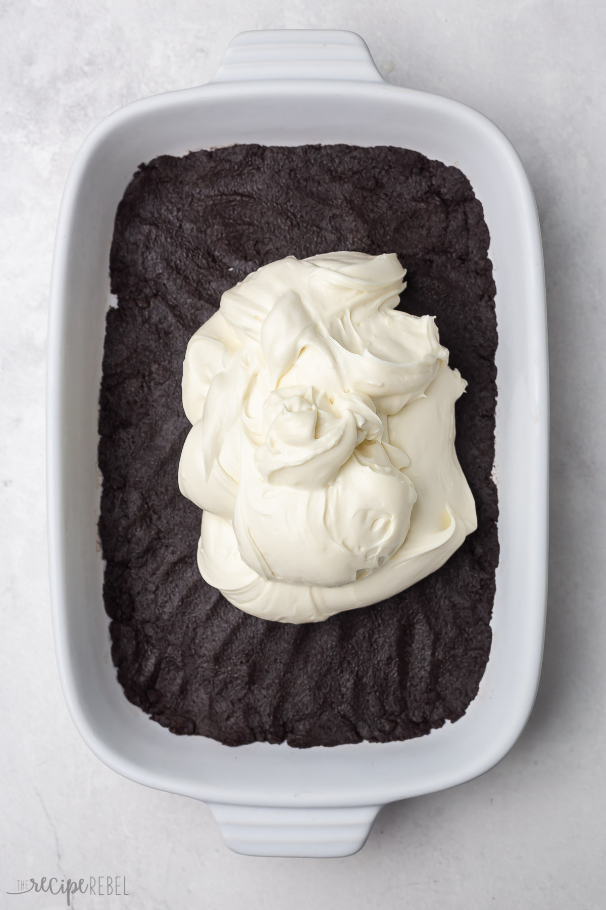 overhead shot of cream cheese mixture on crust of chocolate lasagna.