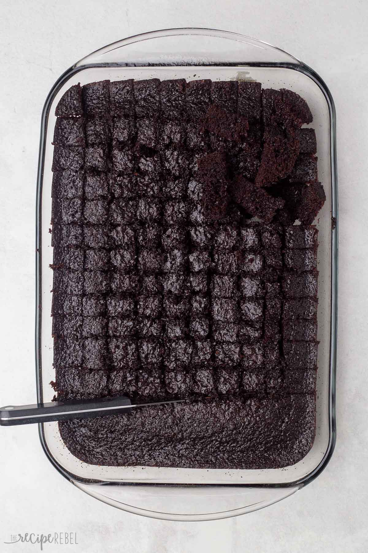 cubed chocolate cake in glass pan.