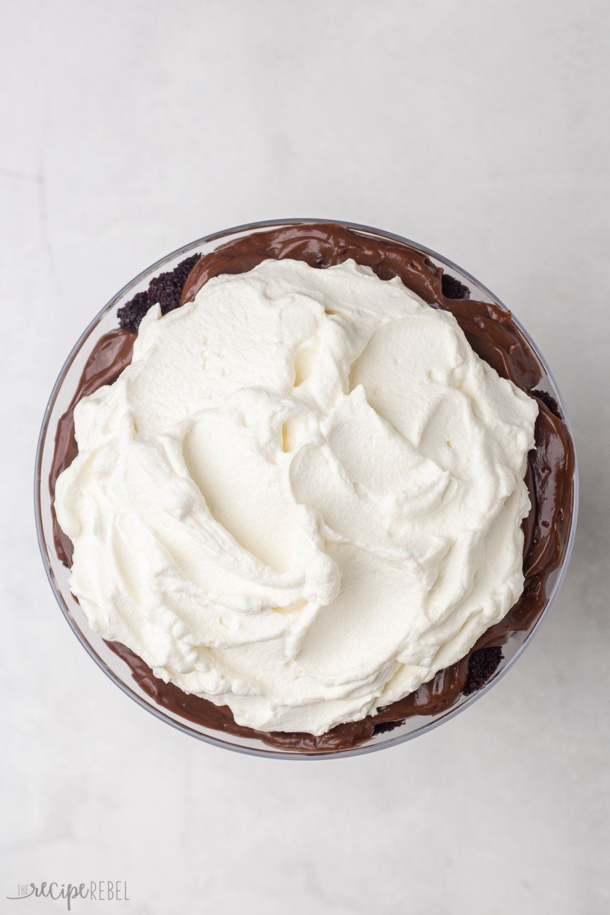 spread whipped cream on top of chocolate trifle.