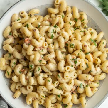 overhead image of cavatappi pasta in grey and white bowl.