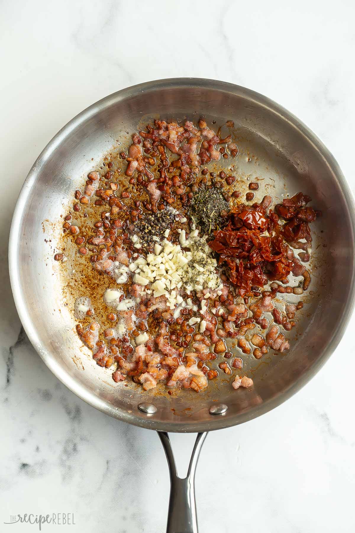 garlic and seasonings added to bacon in skillet.